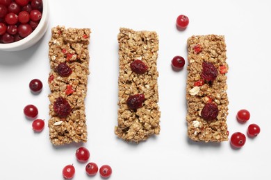 Tasty granola bars and berries on white background, flat lay