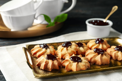 Tasty shortbread cookies with jam on table
