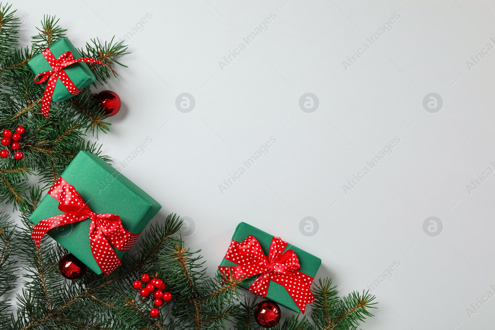 Photo of Gift boxes, Christmas balls and fir branches on grey background, flat lay. Space for text