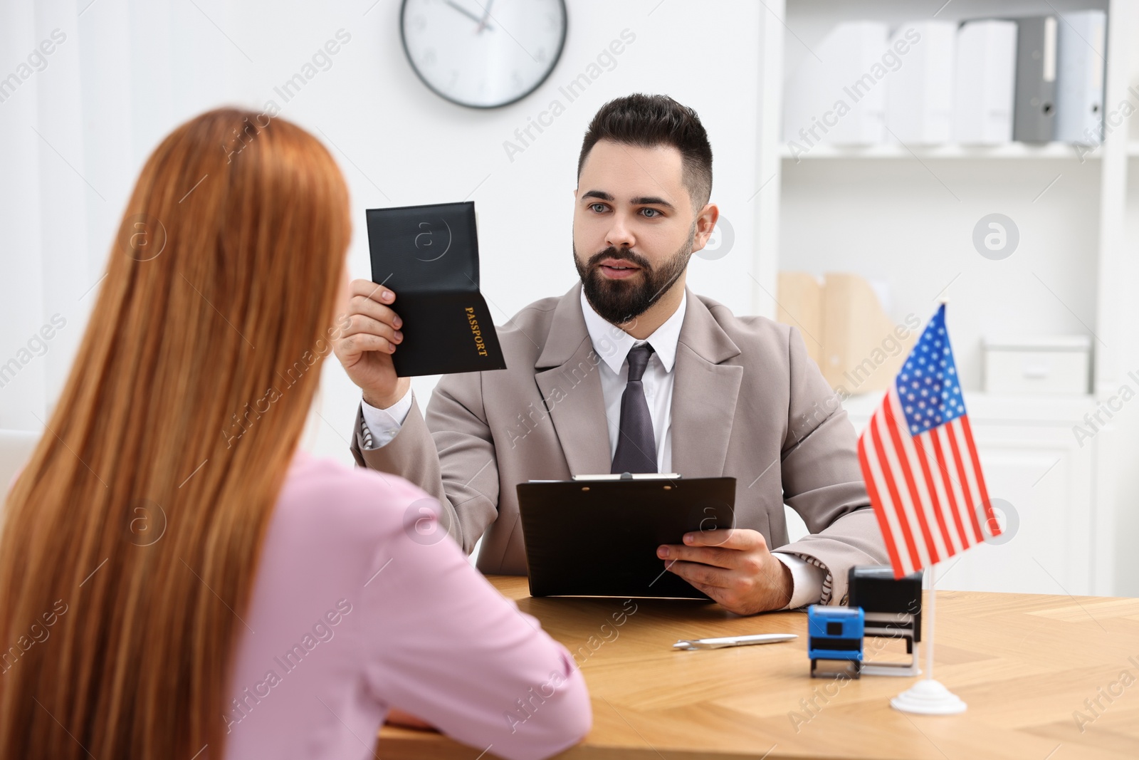 Photo of Immigration to United States. Woman having interview with embassy worker in office