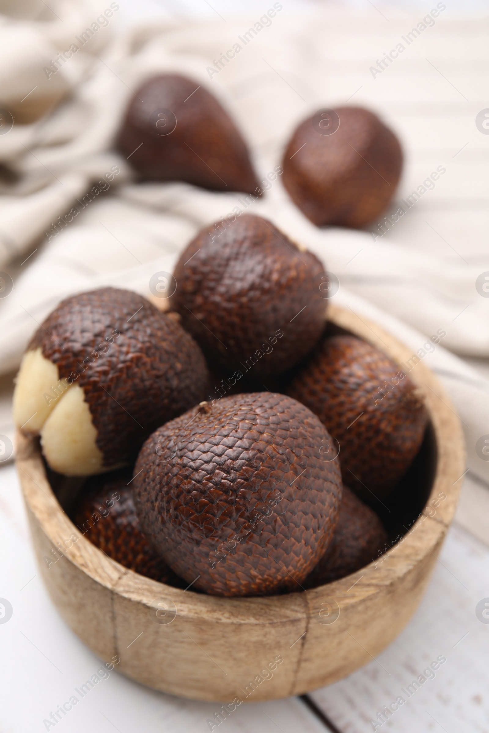 Photo of Fresh salak fruits in bowl on table, closeup