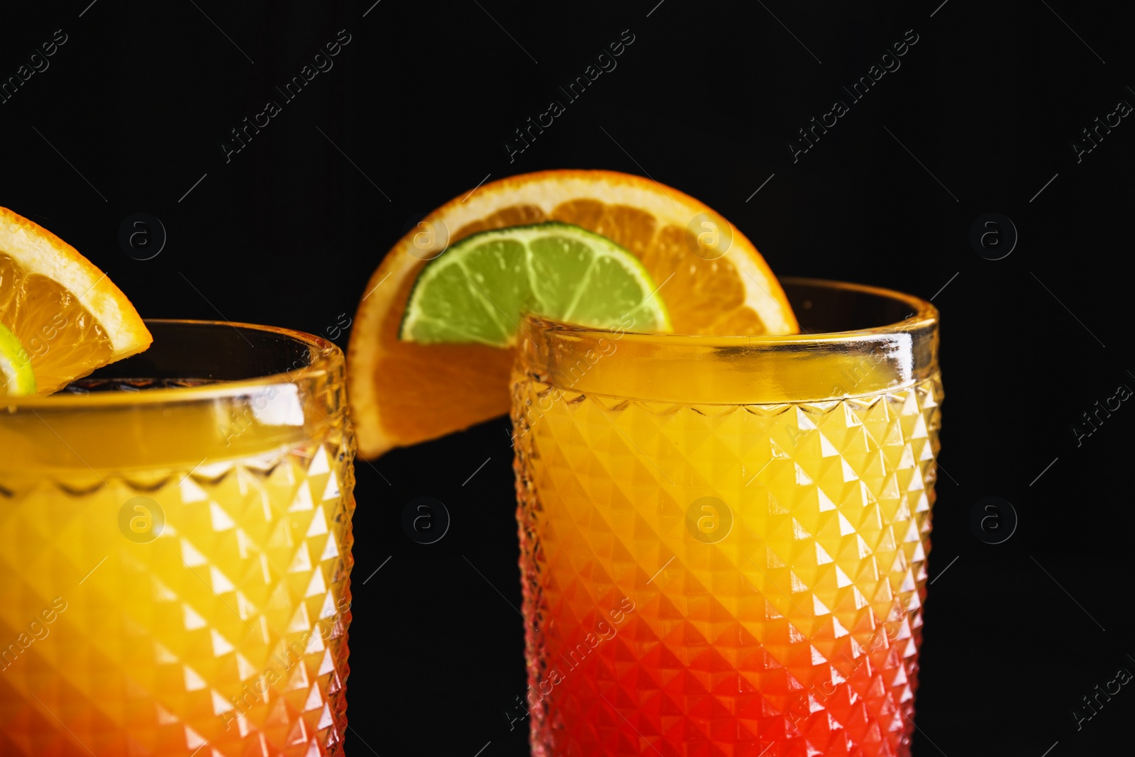 Photo of Fresh alcoholic Tequila Sunrise cocktails on dark background, closeup