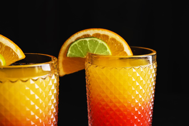 Fresh alcoholic Tequila Sunrise cocktails on dark background, closeup