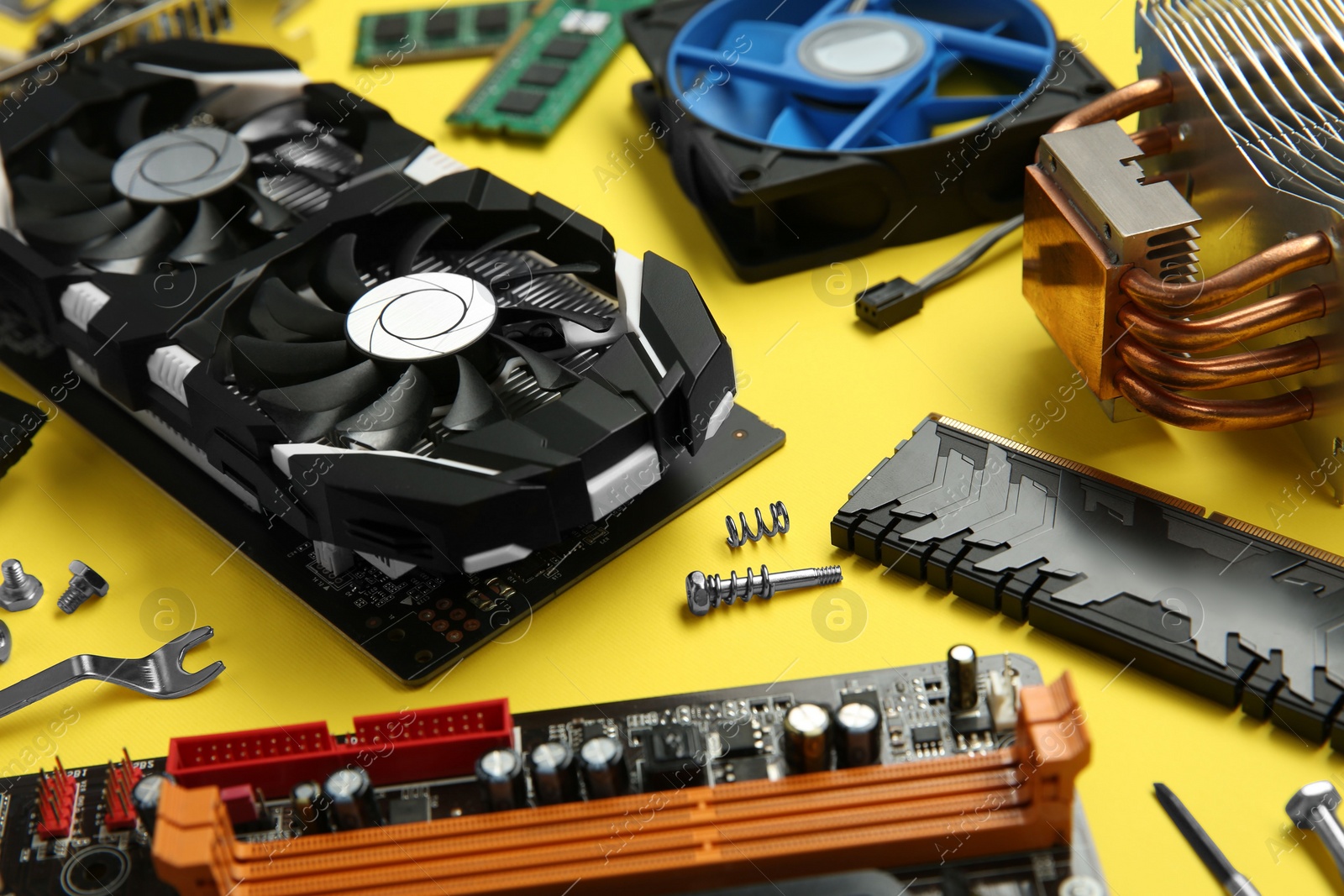 Photo of Graphics card and other computer hardware on yellow background, closeup