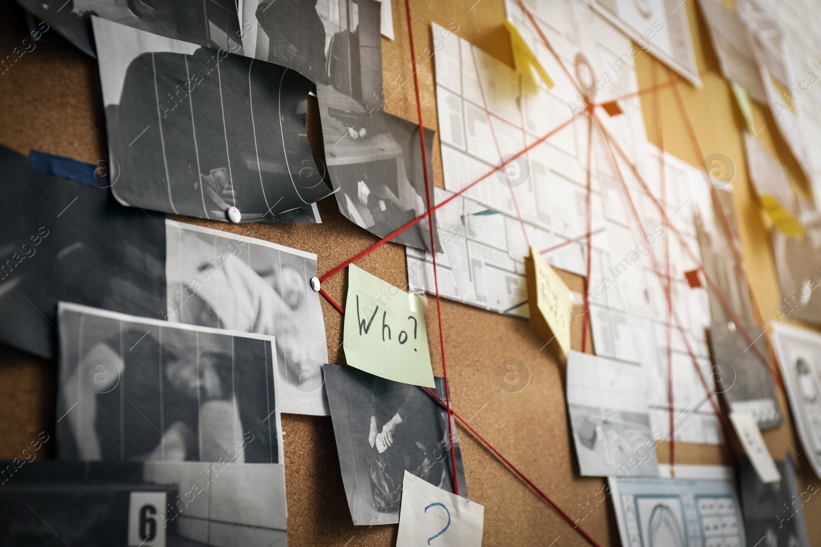 Photo of Detective board with sticker, crime scene photos and red threads, closeup