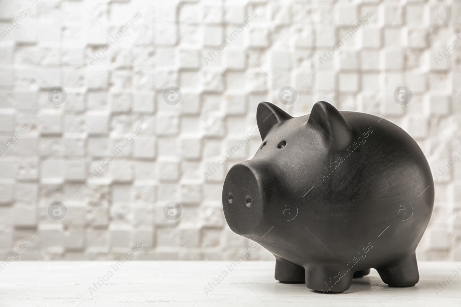 Photo of Black piggy bank on table against light background