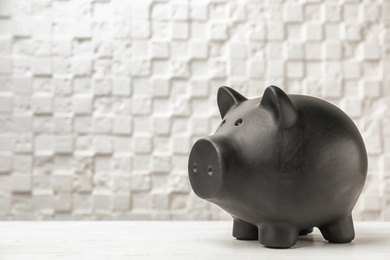 Photo of Black piggy bank on table against light background