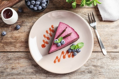 Photo of Flat lay composition with piece of tasty blueberry cake on wooden  table