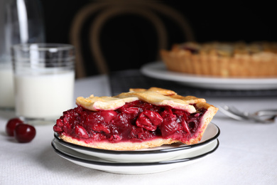 Photo of Slice of delicious fresh cherry pie on table against dark background, closeup