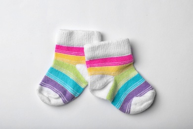 Pair of cute child socks on white background, top view