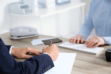 Man filling blank at cash department window, closeup