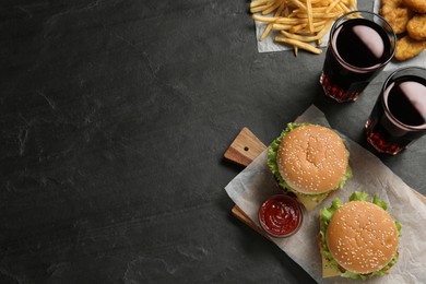 Photo of Flat lay composition with delicious fast food menu on black table. Space for text