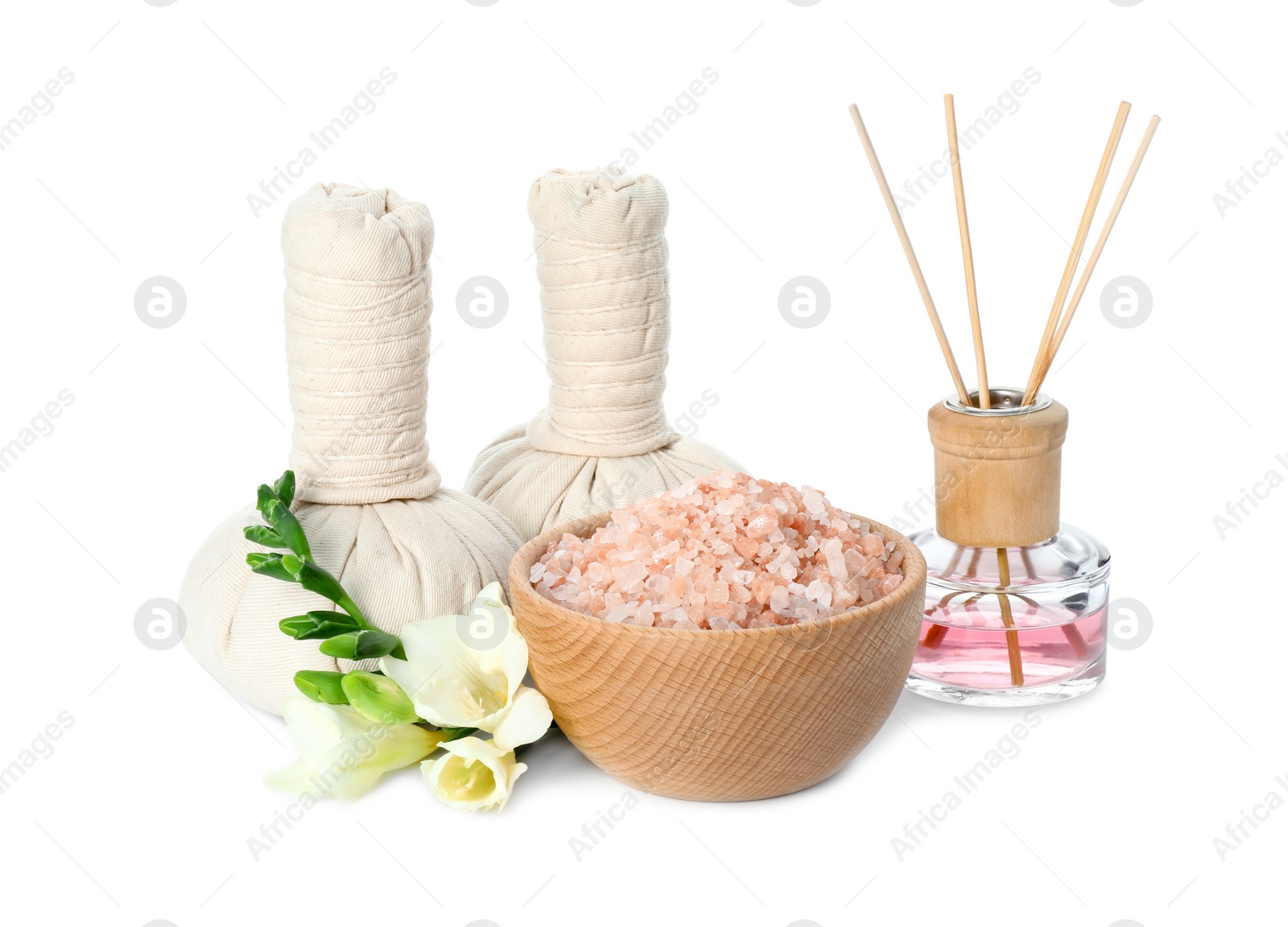 Photo of Spa composition. Herbal massage bags, sea salt, reed air freshener and beautiful flowers on white background