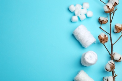 Flat lay composition with cotton rolls and balls on color background, space for text