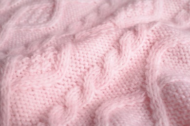 Pink knitted sweater as background, closeup view