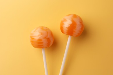 Tasty lollipops on orange background, flat lay