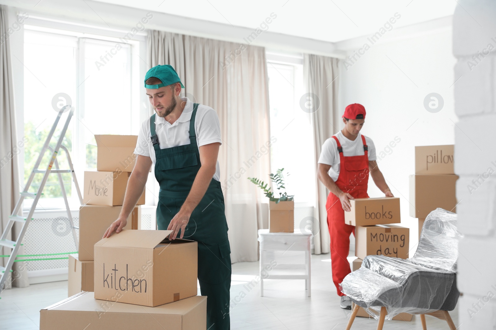 Photo of Male movers with boxes in new house