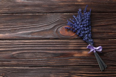 Photo of Bouquet of beautiful preserved lavender flowers on wooden table, top view. Space for text