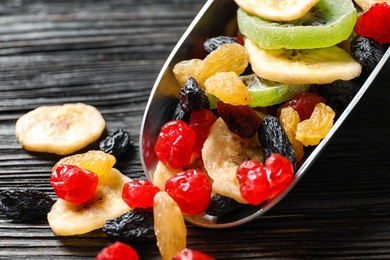 Photo of Scoop with different dried fruits on wooden background, closeup. Healthy lifestyle