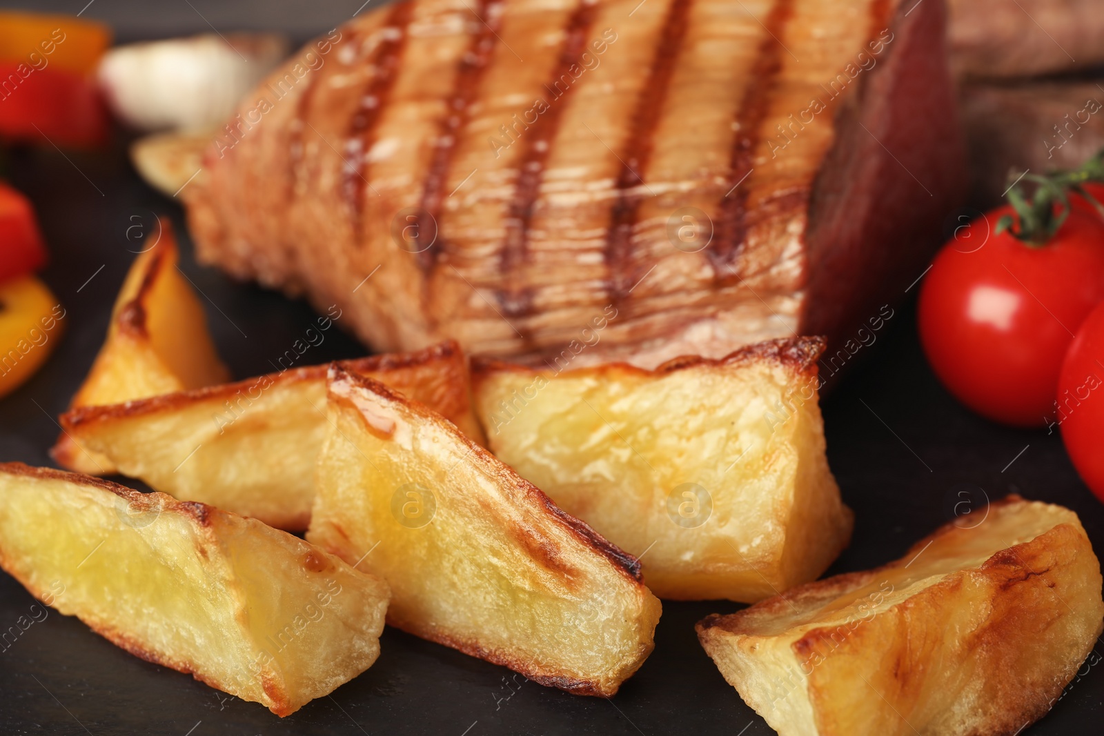 Photo of Grilled meat with garnish on slate plate, closeup