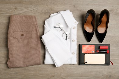 Photo of Flat lay composition with clothes, shoes and accessories on wooden background. Packing for business trip