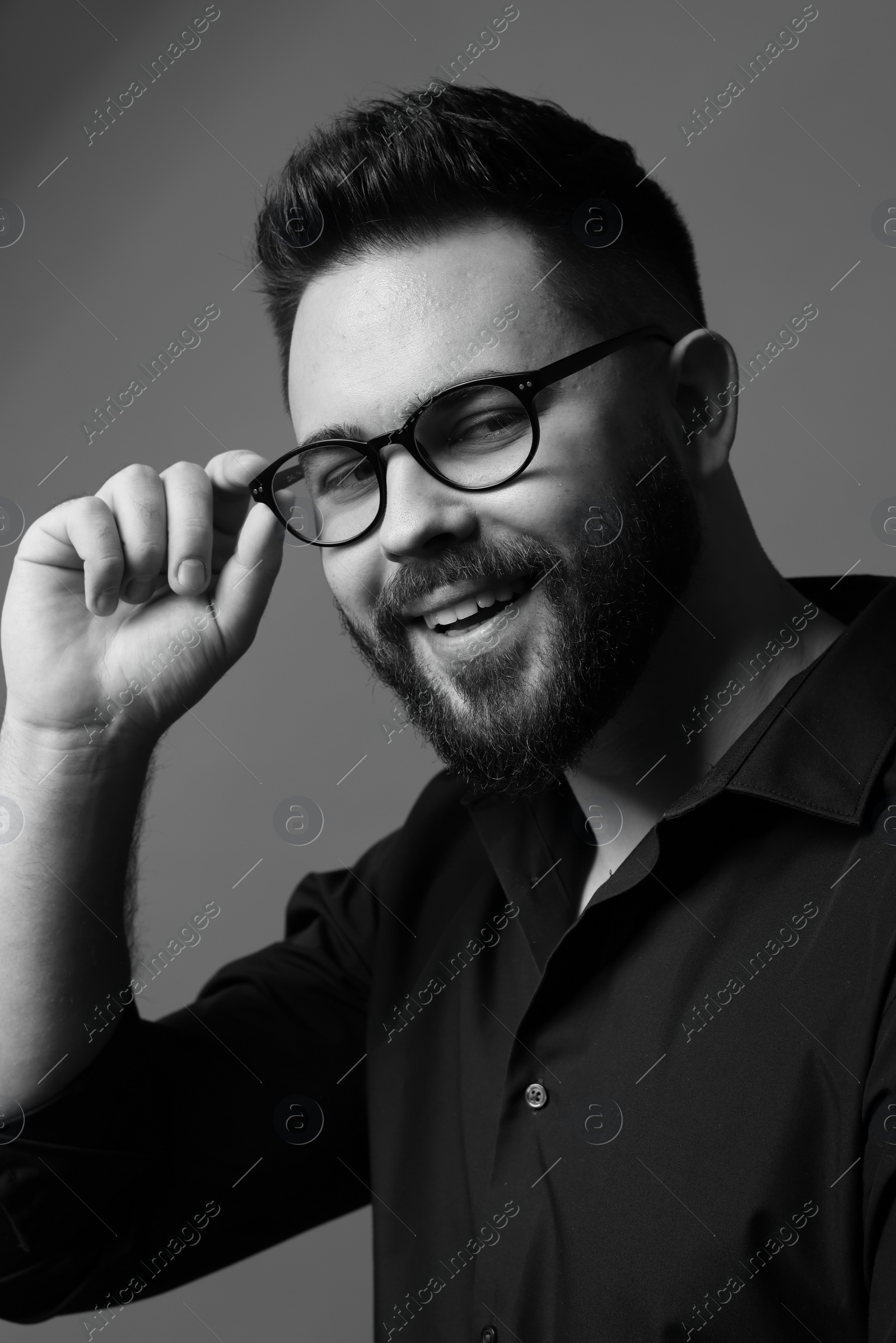 Photo of Portrait of handsome bearded man on grey background. Black and white effect