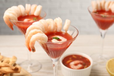 Photo of Tasty shrimp cocktail with sauce on table, closeup