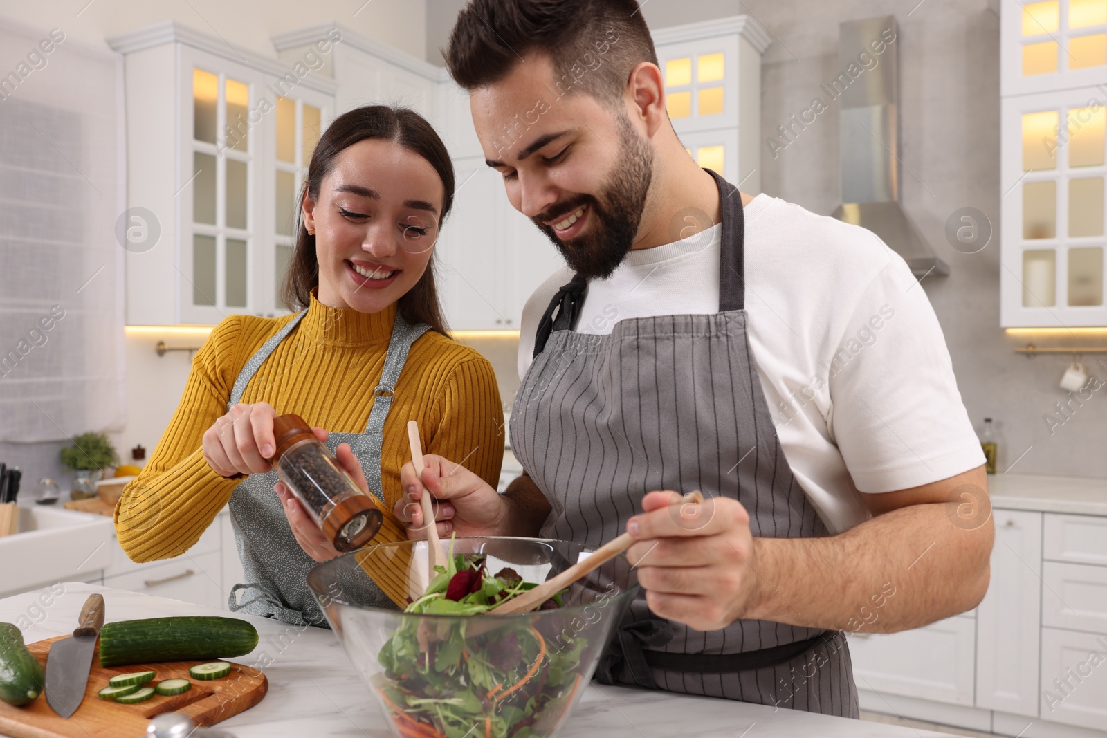 Photo of Lovely young couple cooking together in kitchen