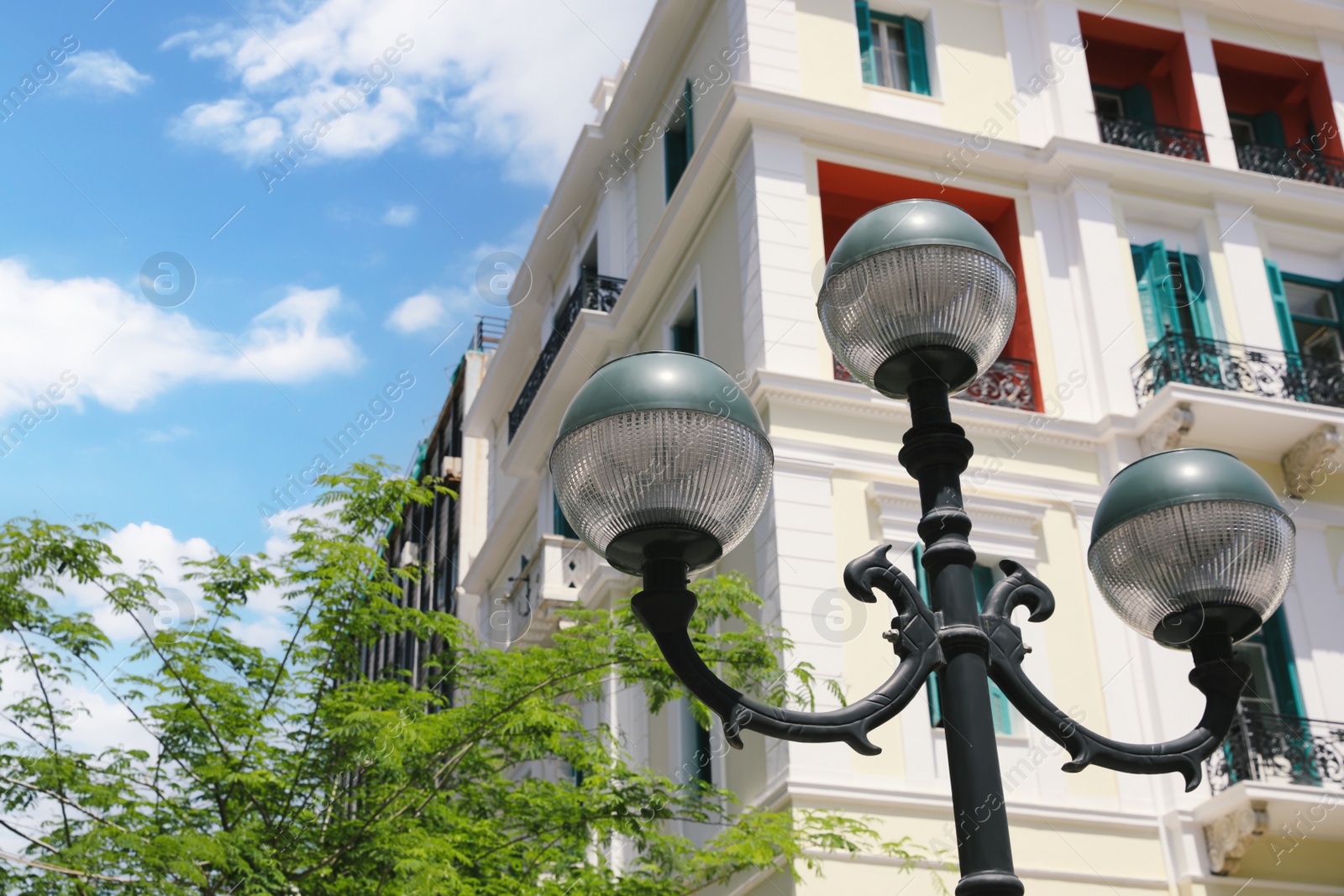 Photo of Old fashioned streetlight near building on sunny day