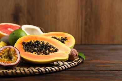 Fresh ripe papaya and other fruits on wooden table. Space for text