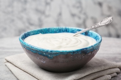 Bowl with tasty yogurt on table