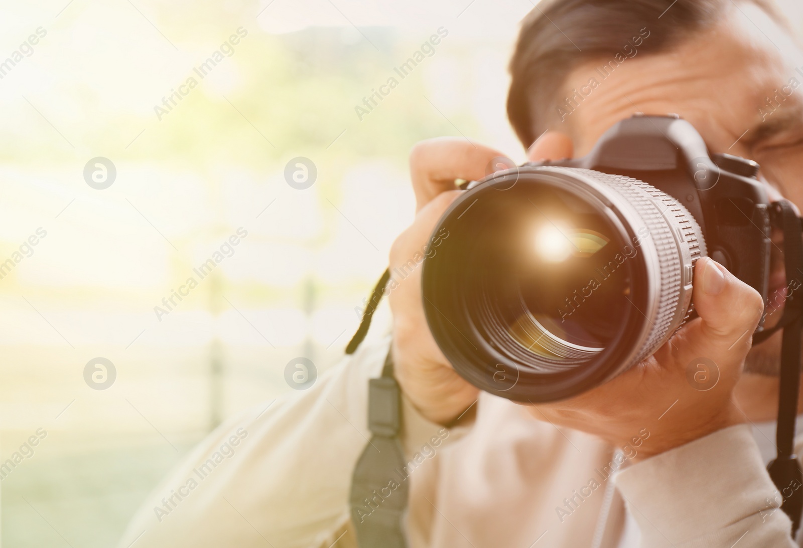 Image of Photographer with professional camera on blurred background. Space for text