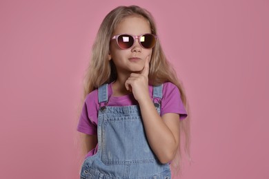 Girl in stylish sunglasses on pink background