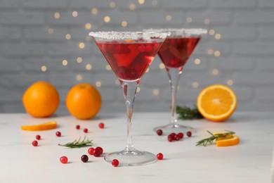 Tasty cranberry cocktail in glasses on white table