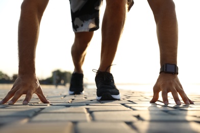 Photo of Man with fitness tracker training outdoors, closeup