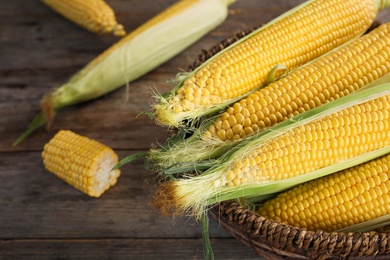 Basket with tasty sweet corn cobs on table, closeup