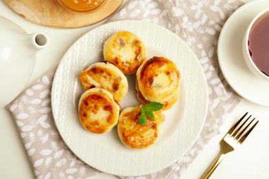 Delicious cottage cheese pancakes on white table, flat lay