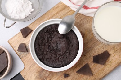 Tasty chocolate pie and ingredients on light grey table, flat lay. Microwave cake recipe