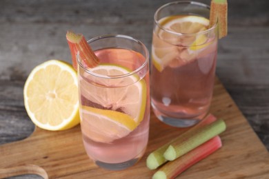 Tasty rhubarb cocktail with lemon on wooden table