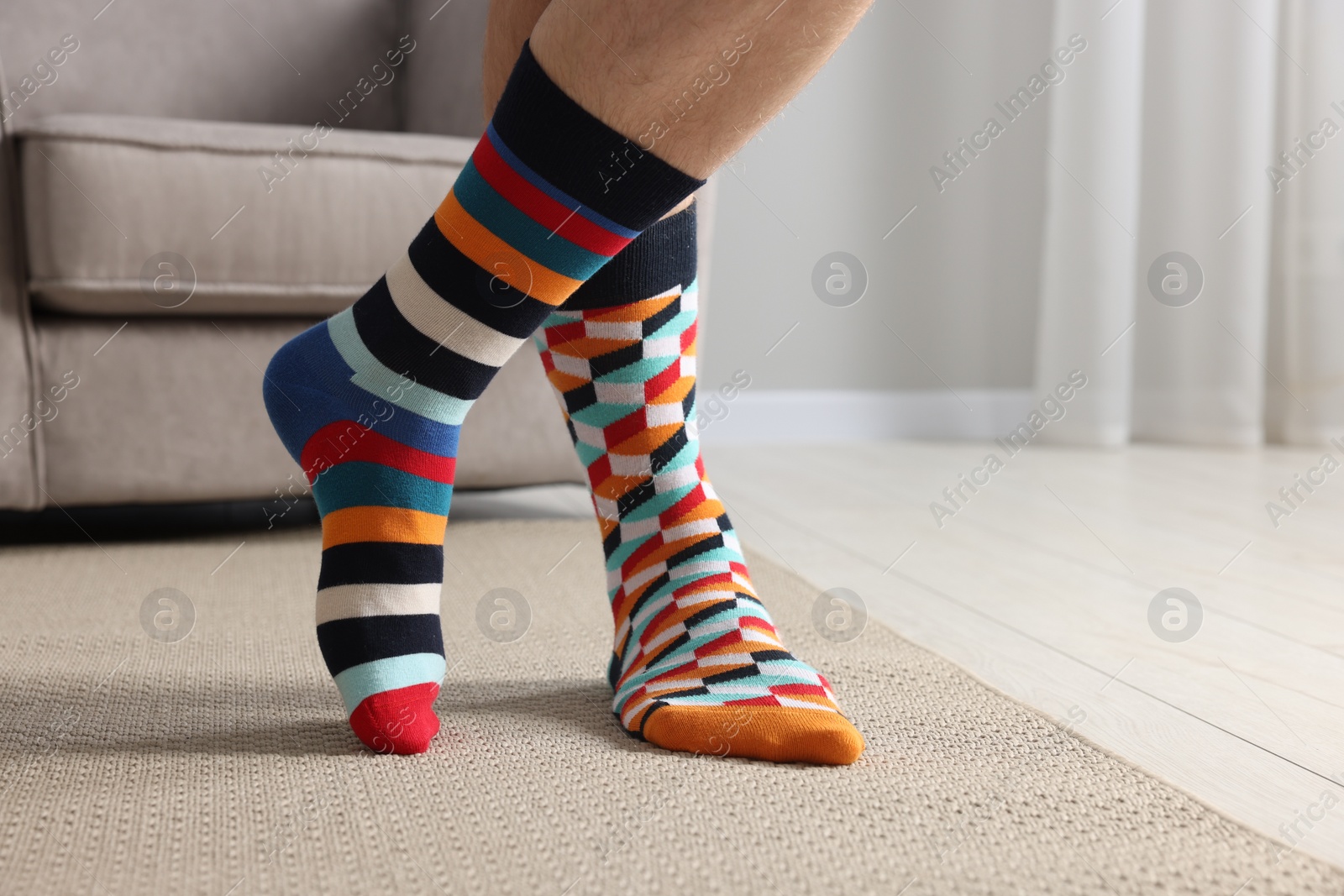 Photo of Man in different stylish socks indoors, closeup. Space for text