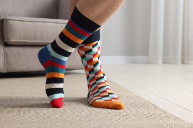 Photo of Man in different stylish socks indoors, closeup. Space for text