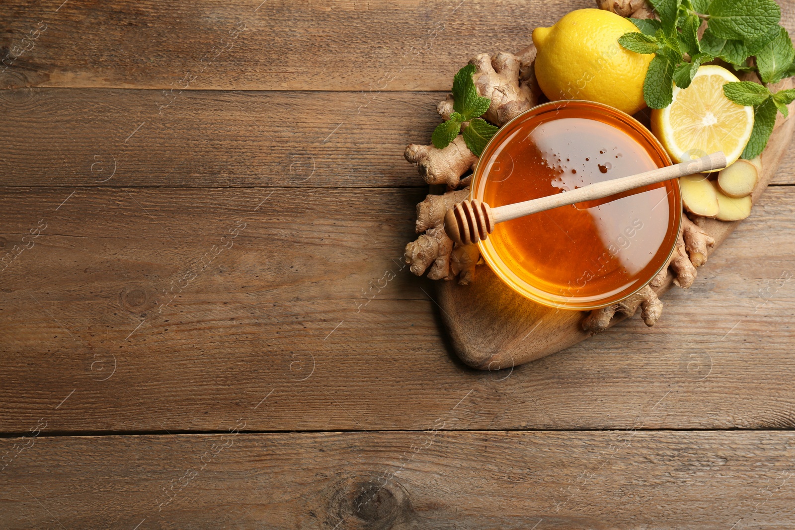 Photo of Ginger and other natural cold remedies on wooden table, top view. Space for text