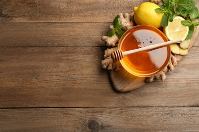 Photo of Ginger and other natural cold remedies on wooden table, top view. Space for text