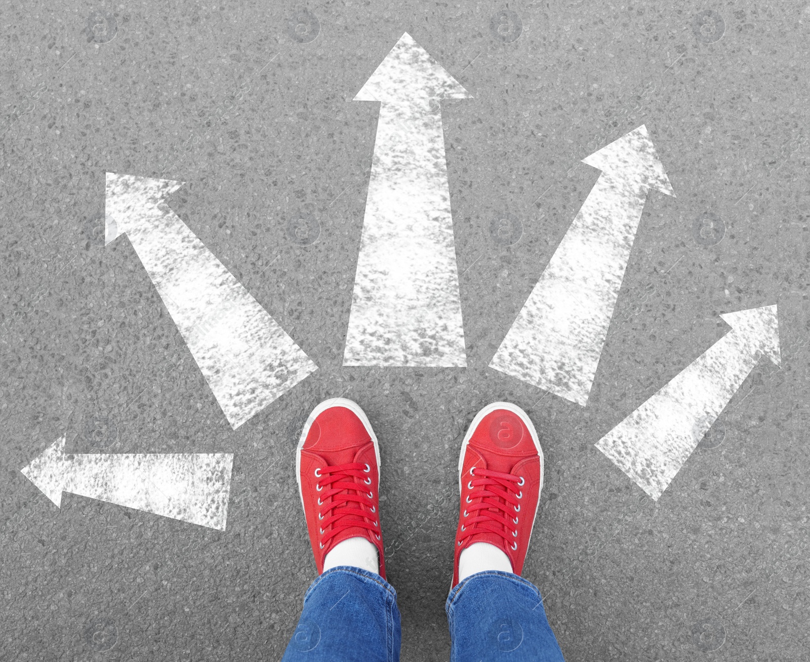 Image of Choosing future profession. Girl standing in front of drawn signs on asphalt, top view. Arrows pointing in different directions symbolizing diversity of opportunities