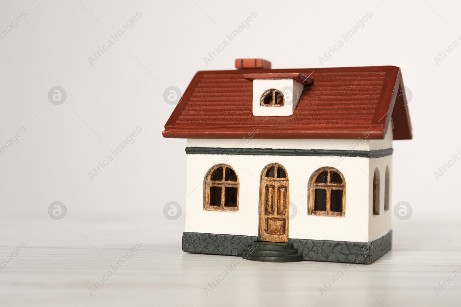 Photo of Mortgage concept. House model on white wooden table, space for text