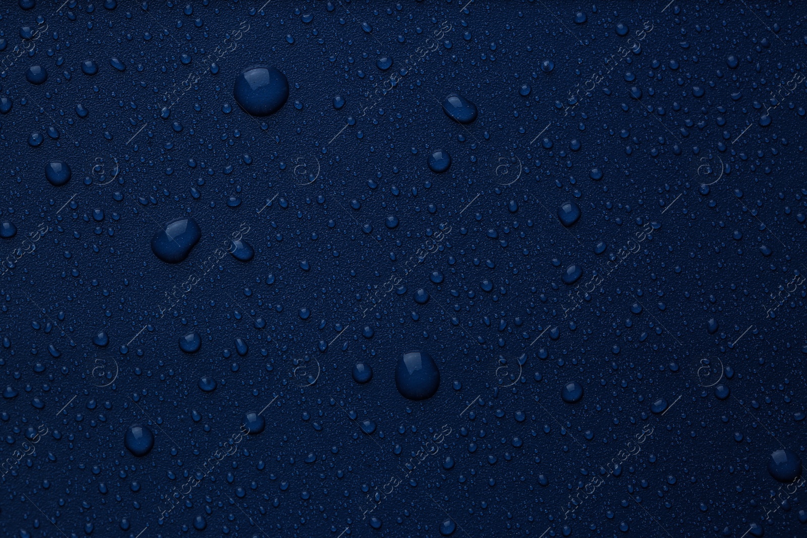 Photo of Many water drops on bright blue background