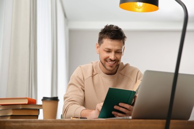 Man reading book at table in library