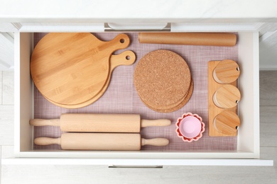 Open drawer with wooden utensils indoors. Order in kitchen