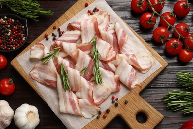 Photo of Slices of raw bacon and fresh products on wooden table, flat lay