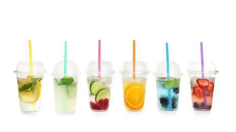 Photo of Plastic cups with lemonades on white background